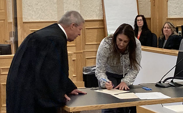 Signing papers. Photo by Dawn Ballou, Pinedale Online.